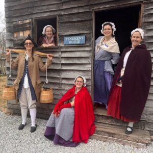 Five women dressed in 18th-century colonial attire.